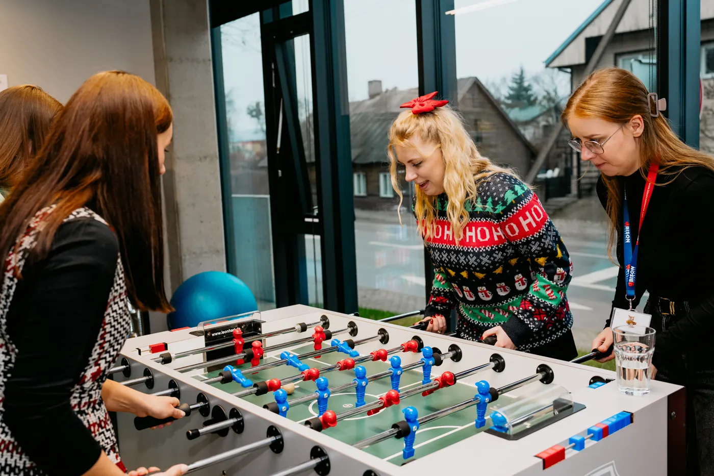 A foosball match in festive sweaters at the Christmas gathering