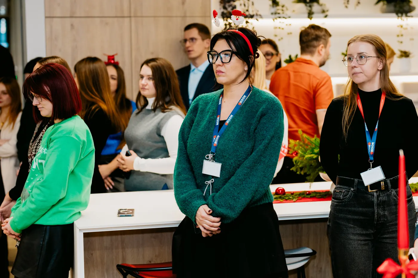 Teammates in Christmas sweaters in the office lounge