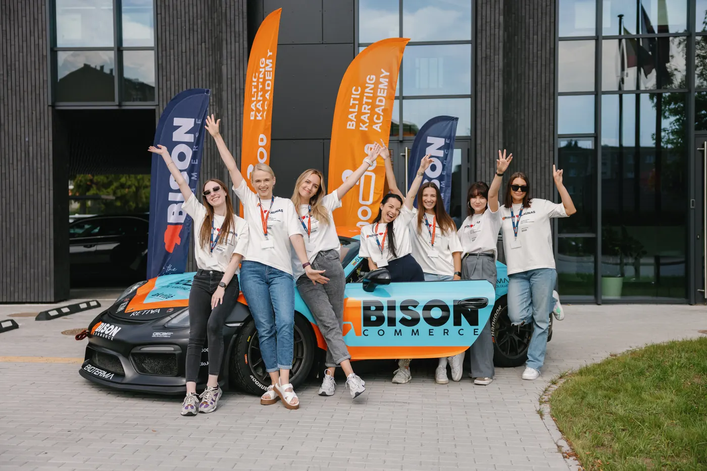 Teammates with the Bison race car and flags at the race weekend