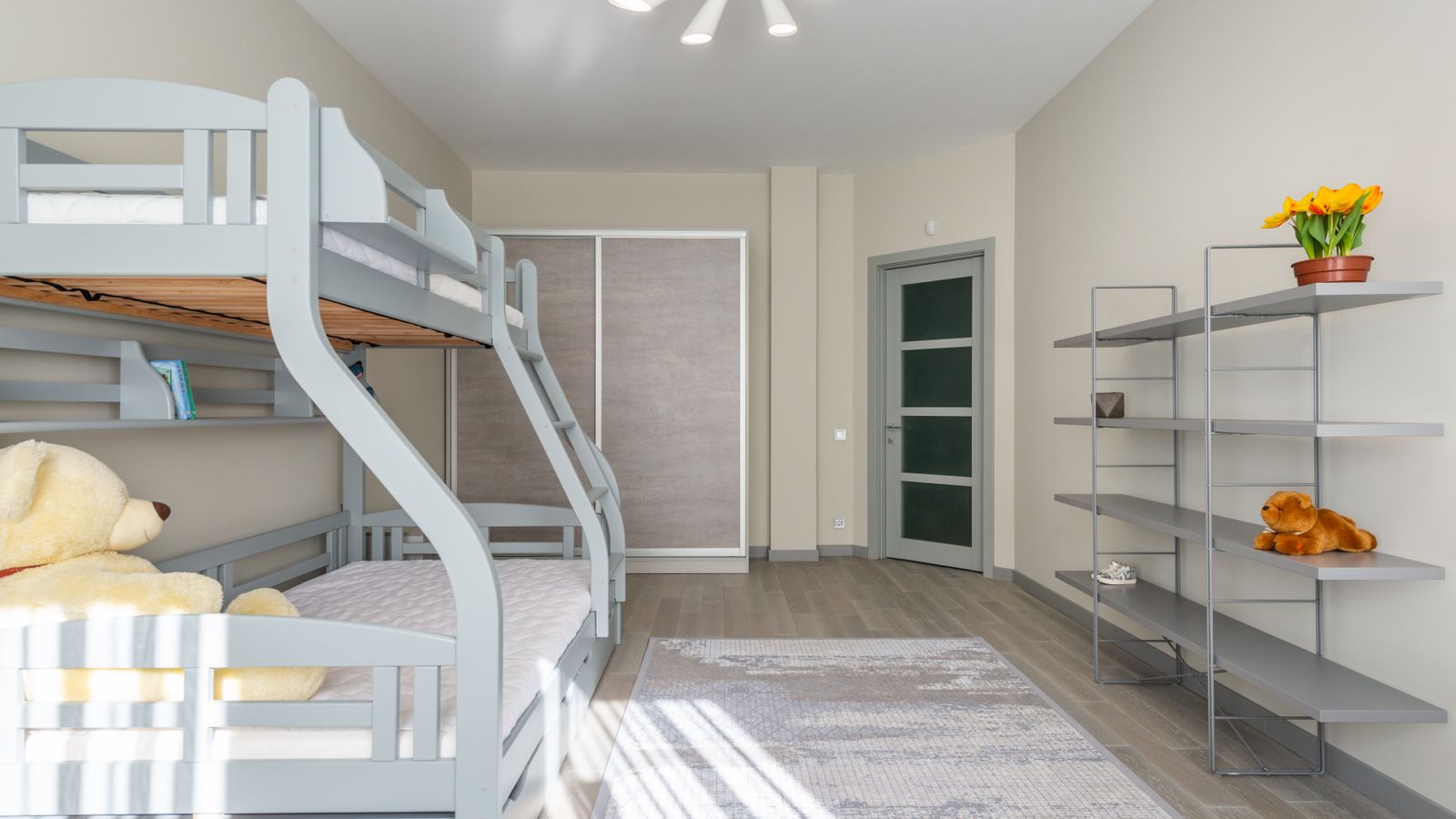 A kids' bedroom furnished with a bunk bed and shelving