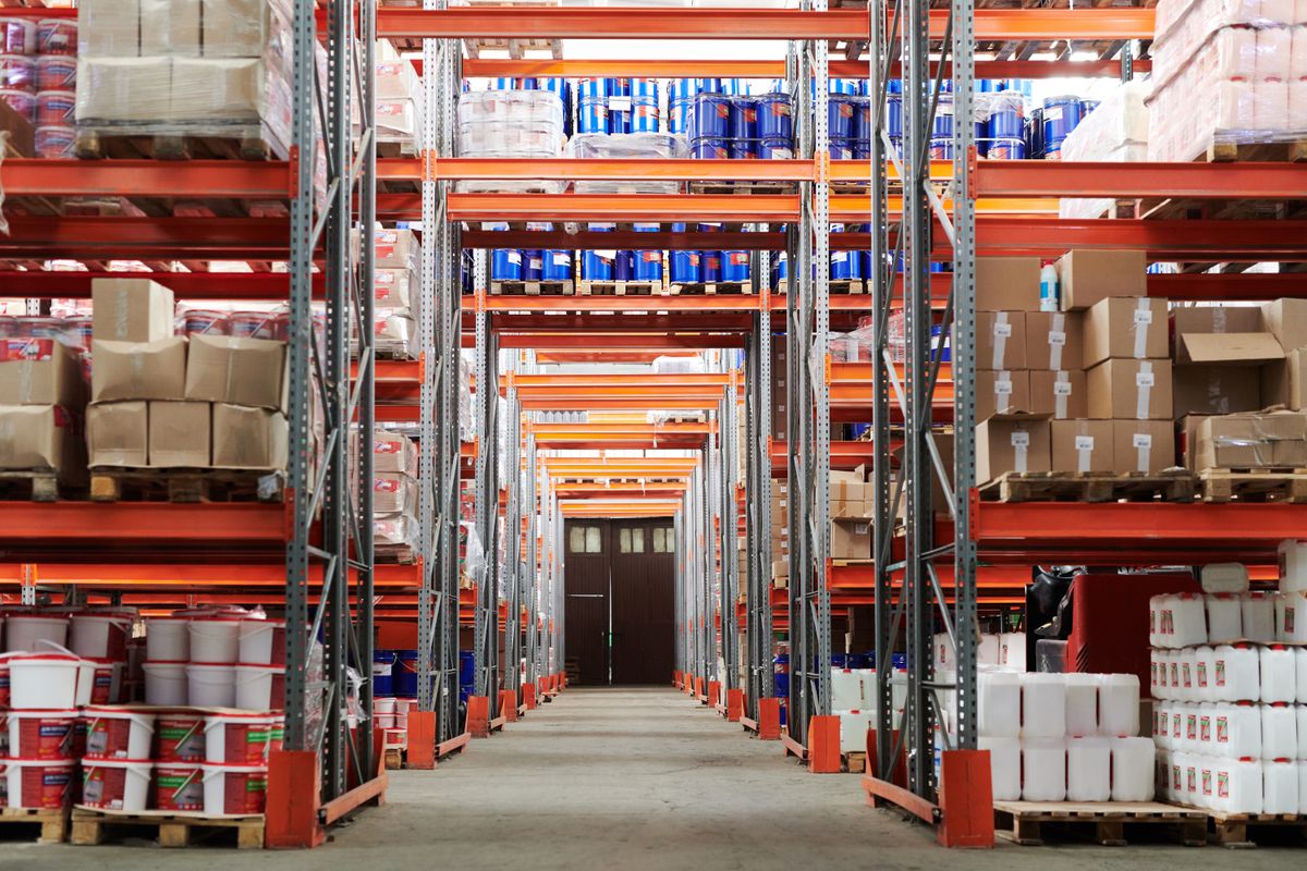 A warehouse aisle of racked pallets and boxed inventory