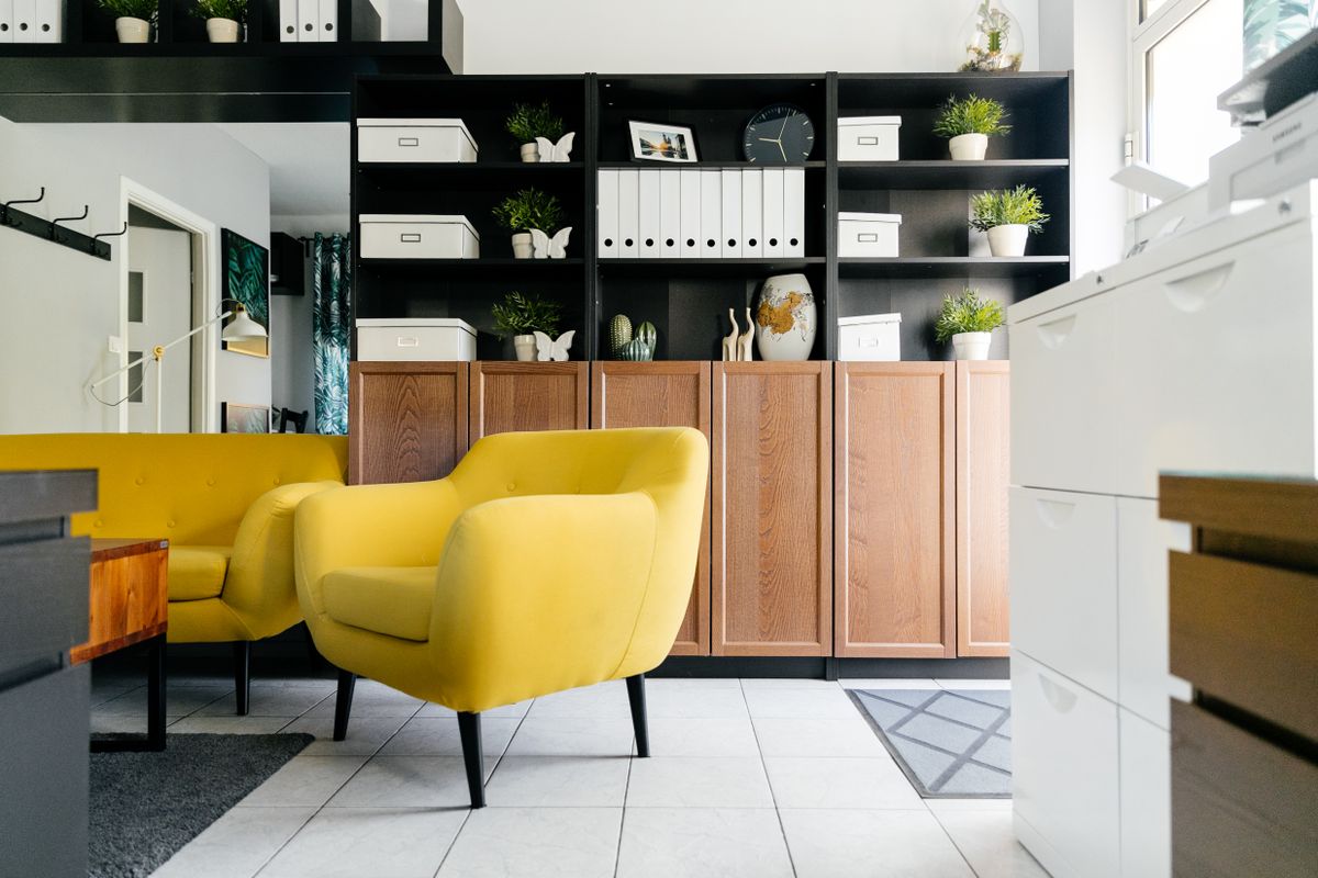 A furnished living room with wood storage cabinets and shelving