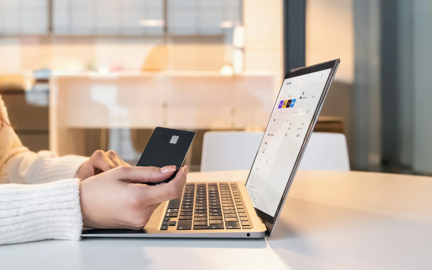 A customer holding a credit card while checking out on the Bison Furniture storefront